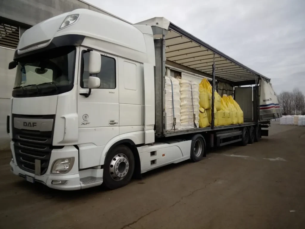 Camion DAF con telone aperto e pallet di sacchi e colli caricati